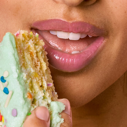 [A close up of a model wearing Tower 28 Beauty's LipSoftie™ Lip Treatment in Confetti Cake on her lips]